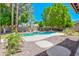 Backyard pool with rock waterfall feature, easy-access steps and lush greenery at 1470 W Bartlett Way, Chandler, AZ 85248