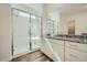 The bright bathroom features a walk-in shower, granite countertop and vanity at 15041 W Gray Fox Trl, Surprise, AZ 85387
