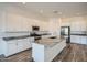 Modern kitchen with an island, granite countertops, stainless steel appliances and white cabinets at 15041 W Gray Fox Trl, Surprise, AZ 85387