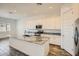 Modern kitchen with an island, granite countertops, stainless steel appliances and white cabinets at 15041 W Gray Fox Trl, Surprise, AZ 85387