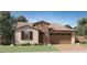 Charming single-Gathering home showcasing a stone facade, a two-car garage, and a perfectly manicured front lawn at 15824 W Kendall St, Goodyear, AZ 85338