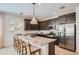 Modern kitchen featuring stainless steel appliances, granite countertops, and a breakfast bar at 15824 W Kendall St, Goodyear, AZ 85338
