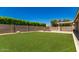 Expansive backyard with manicured lawn, shaded patio area, and privacy landscaping at 16785 W Montana De Oro Dr, Surprise, AZ 85387
