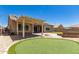 Spacious backyard showcasing a covered patio, built-in fire pit, and putting green at 16785 W Montana De Oro Dr, Surprise, AZ 85387