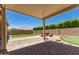 Inviting backyard featuring a covered patio, putting green, artificial grass and custom seating around a modern fire pit at 16785 W Montana De Oro Dr, Surprise, AZ 85387