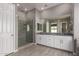 Bathroom featuring granite counters, double sinks, glass enclosed shower, and wood look tile floors at 16785 W Montana De Oro Dr, Surprise, AZ 85387