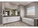 Bathroom featuring granite counters, double sinks, large tub, and wood look tile floors at 16785 W Montana De Oro Dr, Surprise, AZ 85387