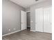 Bedroom features neutral color palette, wood look tile floors, closet, and interior door at 16785 W Montana De Oro Dr, Surprise, AZ 85387
