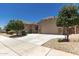 Wide view of the tan stucco home featuring a three-car garage and well-maintained landscaping at 16785 W Montana De Oro Dr, Surprise, AZ 85387