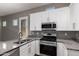 Modern kitchen boasts stainless steel appliances, granite counters and sleek white cabinetry at 16785 W Montana De Oro Dr, Surprise, AZ 85387