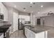 Bright kitchen with granite counters, island, stainless appliances, wood look tile floors and hanging lights at 16785 W Montana De Oro Dr, Surprise, AZ 85387
