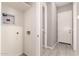 Well-lit laundry area with essential hookups, tiled floors, and adjacent entry and exit doors for convenience at 16785 W Montana De Oro Dr, Surprise, AZ 85387