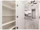 Open pantry with white shelves viewed from an open door with a view to the kitchen and living area at 16785 W Montana De Oro Dr, Surprise, AZ 85387