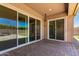 Covered outdoor patio with brick flooring and sliding glass doors to the yard at 16785 W Montana De Oro Dr, Surprise, AZ 85387