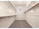Well-organized walk-in closet with shelving and hanging rods, offering ample storage with plush gray carpeting at 16785 W Montana De Oro Dr, Surprise, AZ 85387
