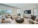Bright living room with a sectional sofa, modern furniture, and large windows with lots of natural light at 16895 W Bronco Trl, Surprise, AZ 85387