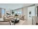 Open concept living room with neutral colors, comfortable seating, and large windows overlooking the backyard at 16895 W Bronco Trl, Surprise, AZ 85387
