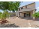 This backyard features a covered patio, a swing set, and low maintenance desert landscaping at 19022 W Shangri La Rd, Surprise, AZ 85388