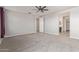 Spacious bedroom features neutral colored walls, neutral carpet, and views of the bathroom and walk-in closet at 19022 W Shangri La Rd, Surprise, AZ 85388