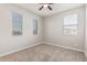 Bedroom with a ceiling fan and three windows offering outdoor views and lots of natural light at 19022 W Shangri La Rd, Surprise, AZ 85388