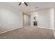 Spacious carpeted bedroom with a ceiling fan and a view into the ensuite bathroom at 19022 W Shangri La Rd, Surprise, AZ 85388