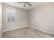 Simple bedroom with neutral walls, carpet, a ceiling fan, and a window with blinds at 19022 W Shangri La Rd, Surprise, AZ 85388