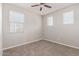 Bedroom with neutral carpet, three windows, and a ceiling fan at 19022 W Shangri La Rd, Surprise, AZ 85388