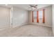 Bedroom featuring carpeted floors, a ceiling fan, and windows with bright orange curtains at 19022 W Shangri La Rd, Surprise, AZ 85388