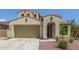 Inviting beige stucco home with a well-manicured desert landscape, a spacious garage, and a welcoming arched entrance at 19022 W Shangri La Rd, Surprise, AZ 85388