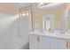 Bright bathroom featuring a double vanity, white cabinetry, and a shower-tub combination at 2031 N 77Th Ln, Phoenix, AZ 85035