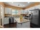 Well-lit kitchen with white cabinetry, stainless steel appliances, and a granite-topped island at 2031 N 77Th Ln, Phoenix, AZ 85035