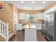 Updated kitchen boasting stainless steel appliances, white cabinetry, and a functional kitchen island at 2031 N 77Th Ln, Phoenix, AZ 85035