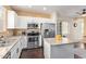 Bright kitchen with stainless appliances, white cabinets, and island, seamlessly connecting to dining area at 2031 N 77Th Ln, Phoenix, AZ 85035