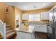 Modern kitchen with island, stainless steel appliances, white cabinets, and seamless access to upstairs at 2031 N 77Th Ln, Phoenix, AZ 85035