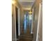 Long hallway with neutral walls, wood-look tile flooring, and multiple doors leading to various rooms at 2110 E Williams Dr, Phoenix, AZ 85024