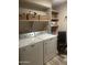 Functional laundry room with modern washer and dryer, ample shelving, and organized storage baskets at 2110 E Williams Dr, Phoenix, AZ 85024