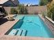 Refreshing backyard pool with sparkling water, tanning ledge, and surrounding desert landscaping and greenery at 2110 E Williams Dr, Phoenix, AZ 85024