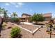 Backyard featuring a swing set, covered patio, mature tree, and desert landscaping at 2177 W Agrarian Hills Dr, San Tan Valley, AZ 85144