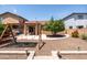 Spacious backyard featuring a swing set, covered patio, and desert landscaping at 2177 W Agrarian Hills Dr, San Tan Valley, AZ 85144