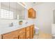 Bright bathroom featuring a double sink vanity with wood cabinets, tile floors and large mirror at 2177 W Agrarian Hills Dr, San Tan Valley, AZ 85144