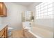 Bright bathroom with a large tub, glass block window and separate glass shower at 2177 W Agrarian Hills Dr, San Tan Valley, AZ 85144