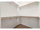 Walk-in closet features white walls, brown flooring, and multiple rods for ample storage at 2177 W Agrarian Hills Dr, San Tan Valley, AZ 85144