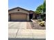 Charming single-story home featuring a two-car garage and desert landscaping with mature trees at 2461 W Muirfield Dr, Anthem, AZ 85086