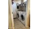 Functional laundry room equipped with a washer, dryer, shelving and tile flooring at 2461 W Muirfield Dr, Anthem, AZ 85086
