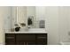Modern bathroom with dark wood cabinets, quartz countertops, and sleek fixtures at 25140 N 174Th Ave, Surprise, AZ 85387