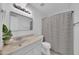Bathroom featuring a stylish mirror, vanity lights, neutral decor, and a shower with a striped curtain at 2812 E Clarendon Ave, Phoenix, AZ 85016