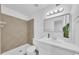 Bright bathroom featuring neutral tile in shower, updated vanity, mirror, and modern lighting at 2812 E Clarendon Ave, Phoenix, AZ 85016
