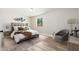 Cozy bedroom with neutral decor, wood floors, sitting chair and decorative wall art at 2941 W Michigan Ave, Phoenix, AZ 85053