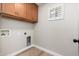 Functional laundry room featuring wooden cabinets, a window and essential hookups for appliances at 2941 W Michigan Ave, Phoenix, AZ 85053