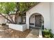 Inviting front entrance with arched doorway, desert landscaping, and a mature shade tree at 3039 W Ross Ave, Phoenix, AZ 85027
